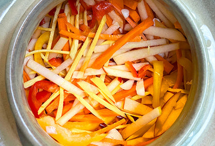 A grey background with bowls of kimchi and fermented food