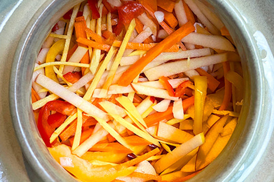 A grey background with bowls of kimchi and fermented food